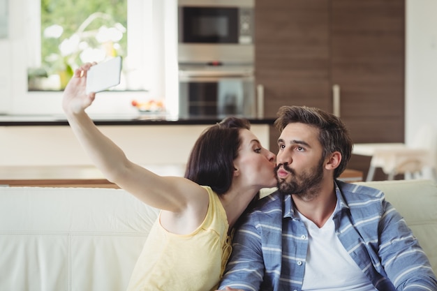 Foto casal romântico relaxando no sofá e tirar uma selfie