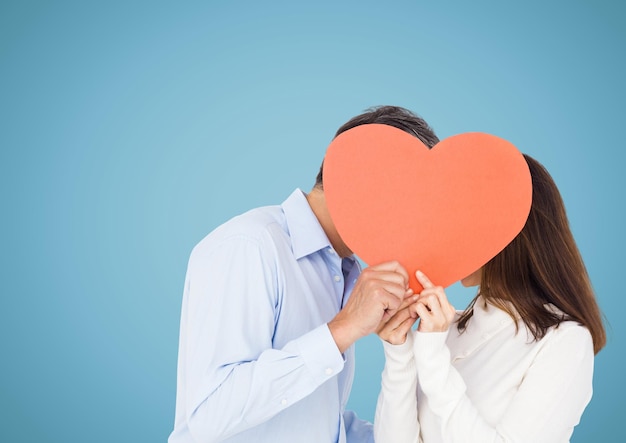 Casal romântico segurando formato de coração e se beijando