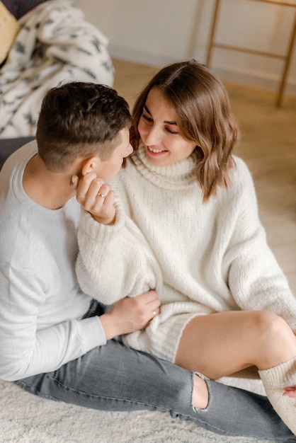 Casal se abraçando em casa perto das decorações de Natal