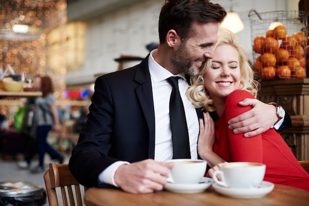 Casal se abraçando na cafeteria