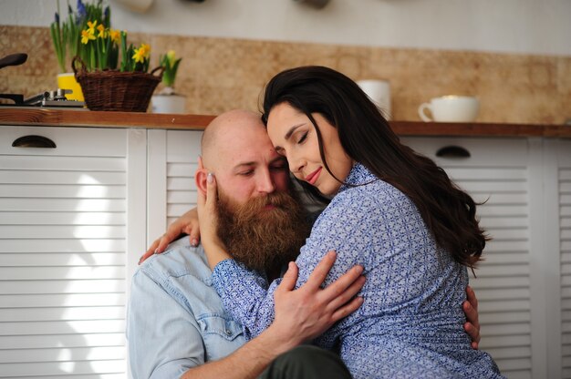 Casal se abraçando na cozinha.