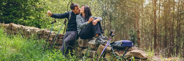 Casal se beijando enquanto faz uma pausa para fazer trekking