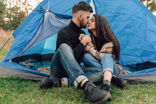 Casal se beijando sentado na barraca