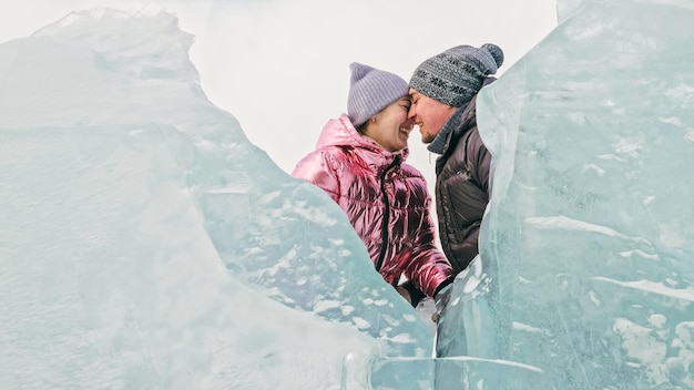 Casal se diverte durante a caminhada de inverno contra o fundo do gelo de f