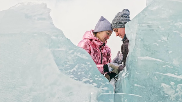 Casal se diverte durante a caminhada de inverno contra o fundo do gelo de f