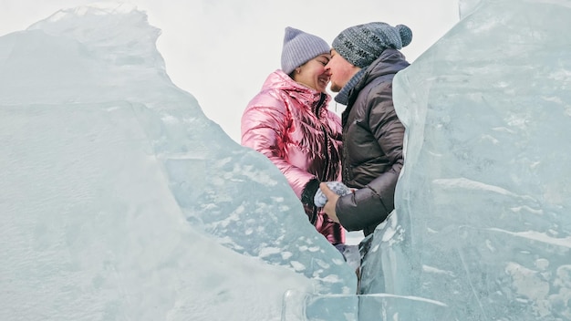 Casal se diverte durante a caminhada de inverno contra o fundo do gelo de f