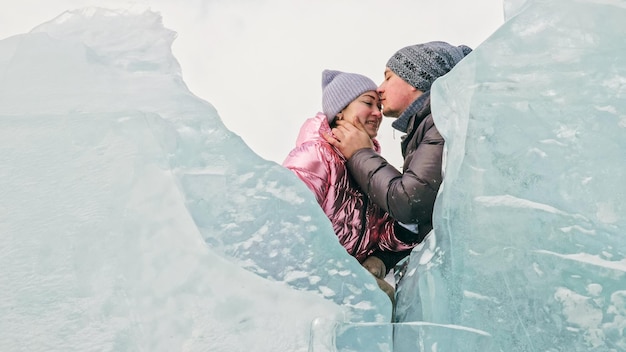 Casal se diverte durante a caminhada de inverno contra o fundo do gelo de f