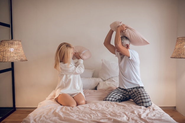 Casal se divertindo no quarto e lutando com os travesseiros