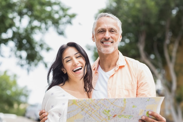 Casal segurando o mapa na cidade