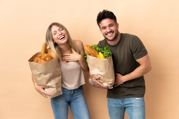 Casal segurando sacolas de compras de supermercado