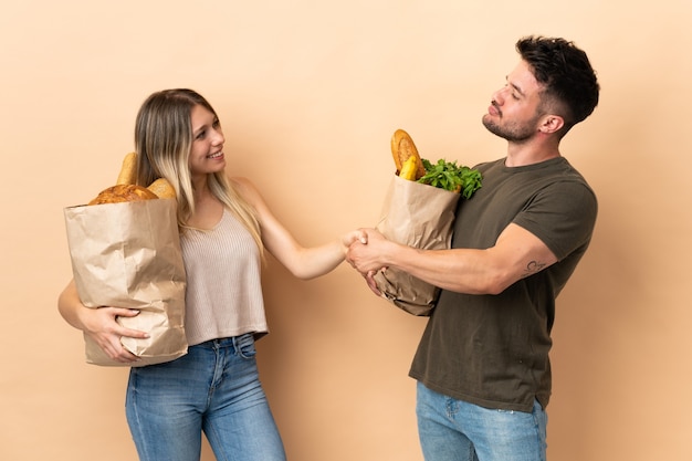 Casal segurando sacolas de compras de supermercado