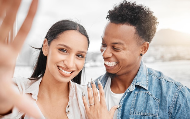 Casal selfie casamento ou jóias de anel de noivado na mão ou anúncio de noiva Retrato de rosto romântico amor ou compromisso de homem casado feliz e mulher na natureza ao ar livre ou fora comemorando