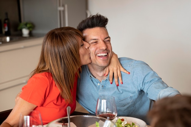 Casal sendo romântico em jantar em família