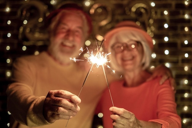 Casal sênior caucasiano turva segurando estrelinhas comemorando o ano novo Estilo de vida feliz para luzes de festa de aposentados maduros