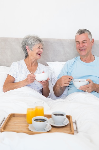 Casal sênior com café da manhã na cama