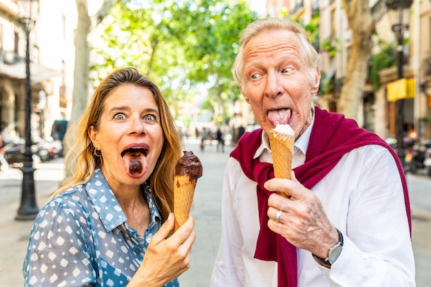 Casal sênior comendo sorvete e se divertindo em Barcelona