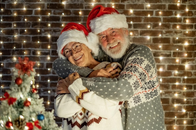 Casal sênior da família Happ se abraçando com amor comemorando as férias de Natal e o ano novo juntos