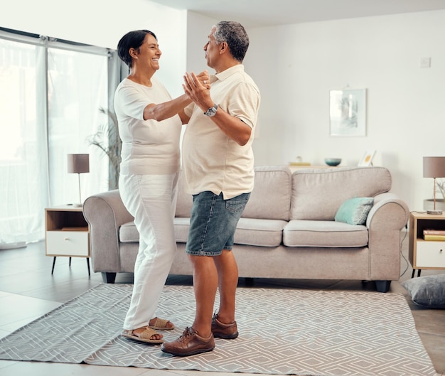 Casal sênior dançando na sala de estar em casa por amor aposentadoria ou imóveis Dançar juntos celebração do casamento e idosos sorriem abraçam e compartilham a vida com carinho liberdade e cuidado