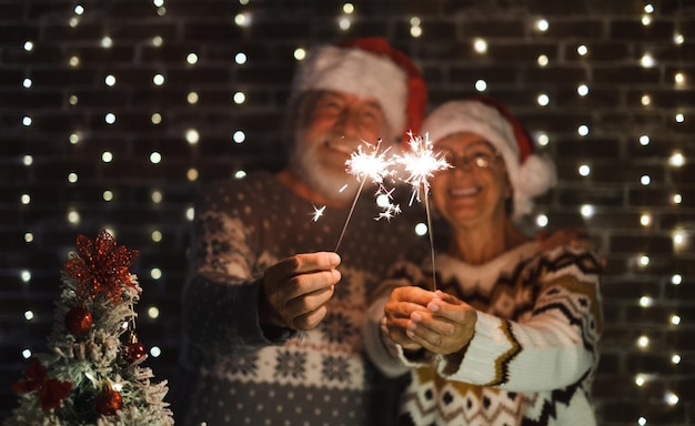 Foto casal sênior desfocado no chapéu de papai noel comemora junto com amor e romance noite de evento de ano novo