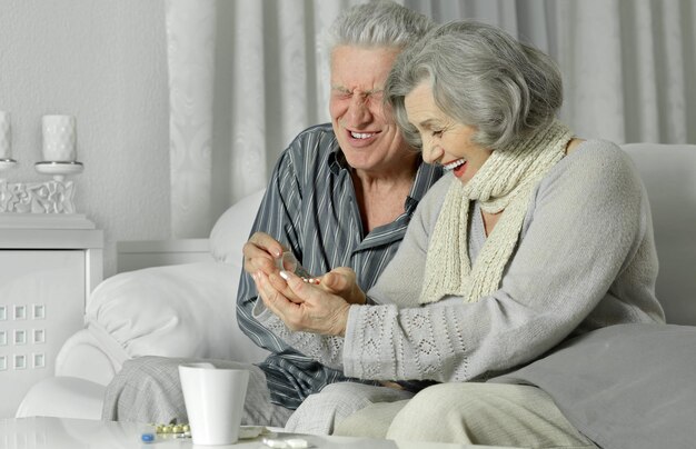 Casal sênior doente tomando pílulas