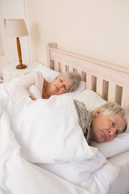 Foto casal sênior dormindo na cama