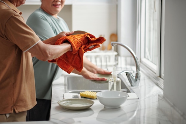Casal sênior lavando pratos
