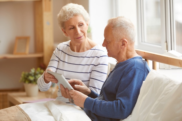 Casal sênior moderno usando tablet