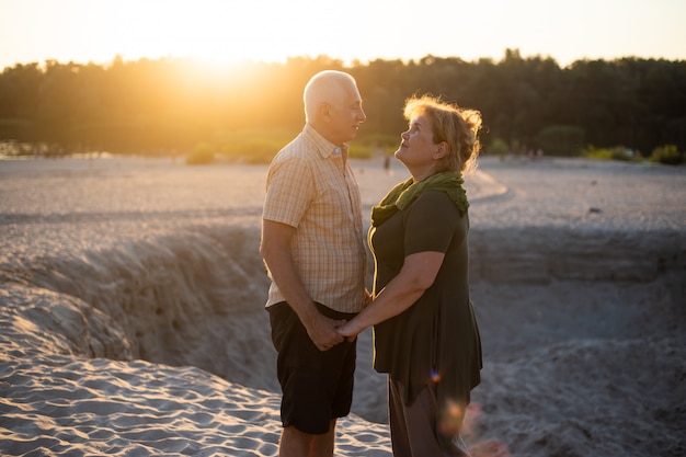 Casal sênior no amor juntos beijando no pôr do sol no verão