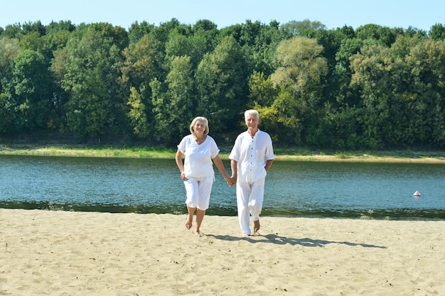 Casal sênior no parque de verão à beira do lago