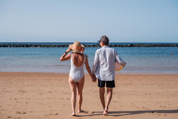 Casal sênior passando um dia ensolarado na praia e aproveitando ativamente sua aposentadoria Conceito de aposentadoria de verão ensolarado