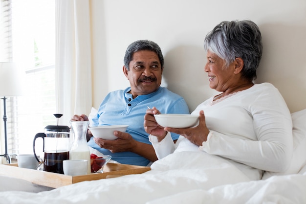 Casal sênior tomando café da manhã no quarto