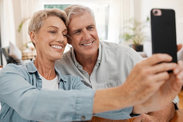 Casal sênior tomando selfie com telefone sorrindo apaixonado por 5g e tecnologia para mídias sociais em casamento em casa Feliz casado e sorridente homem e mulher transmitindo comunicação ou videochamada