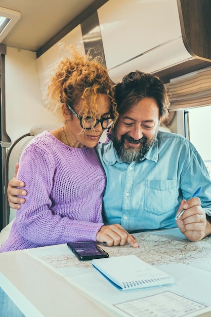 Foto casal sentado em camper planejando viagens sorrindo conceito de vida aventureira