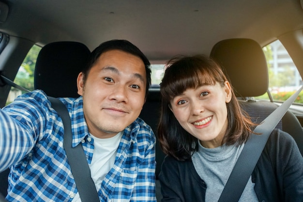 Foto casal sentado em um carro e tirar uma selfie