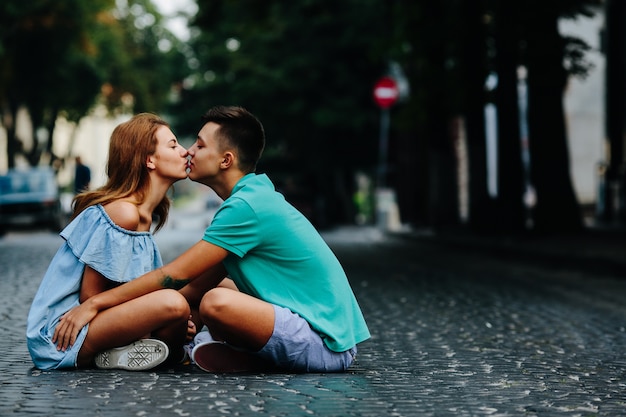 Foto casal sentado na rua caminhando beijando