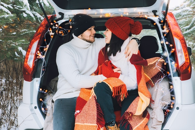 Foto casal sentado no porta-malas do carro no inverno, história de amor