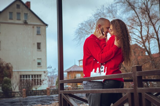 Casal sexy apaixonado abraços em uma varanda, tempo de inverno. Espírito de natal