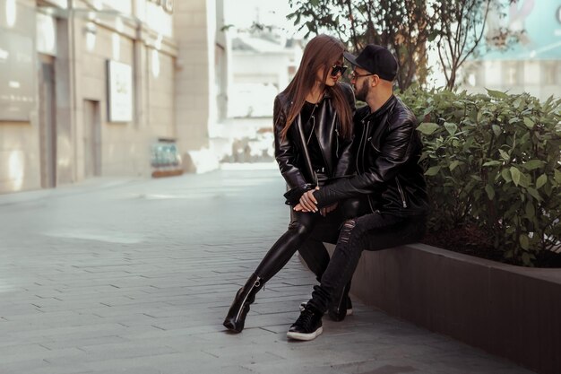 Casal sexy posando em um banco e se olhando na rua