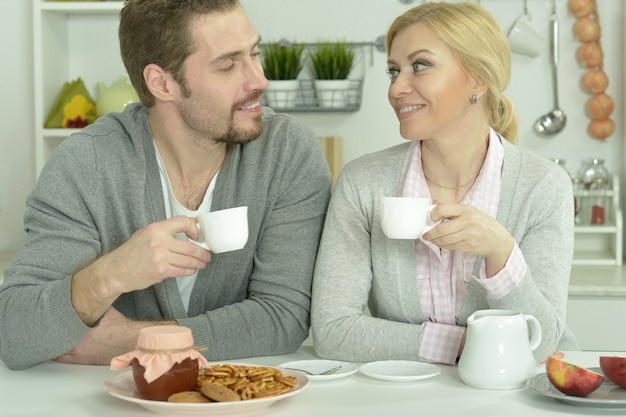 Casal sorridente à mesa com café e comida