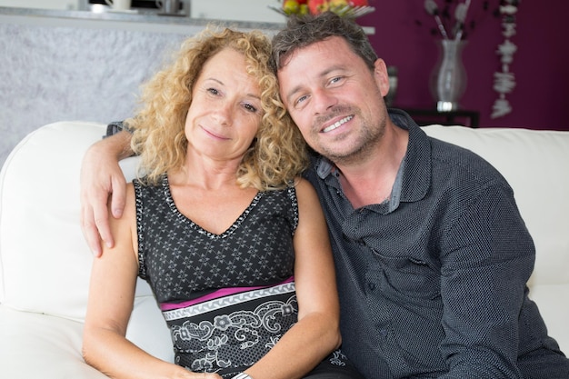 Casal sorridente abraçando em sua sala de estar