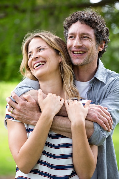 Casal sorridente, abraçando no parque