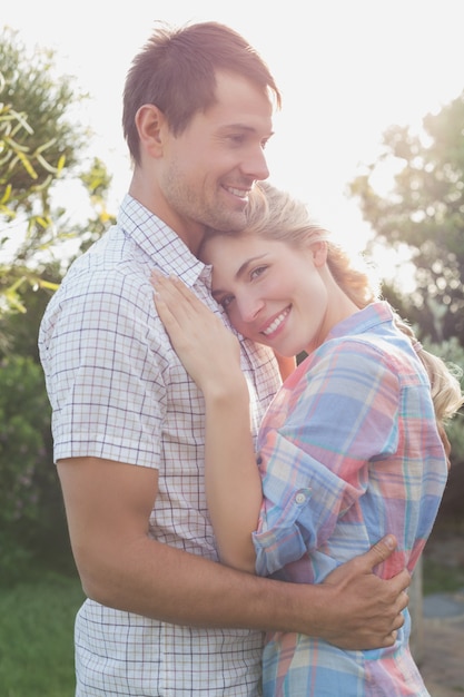 Casal sorridente abraçando no parque