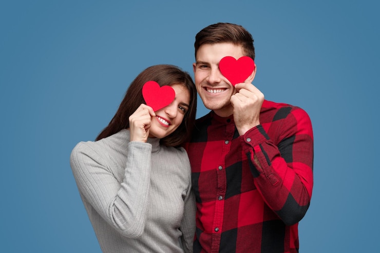 Foto casal sorridente com corações perto dos olhos