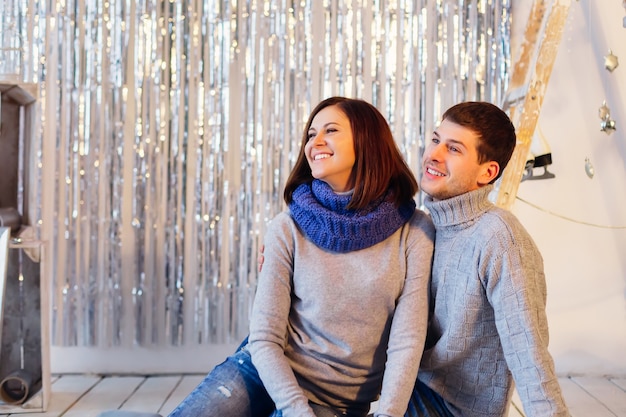 Casal sorridente com roupas de inverno está no lado esquerdo da foto