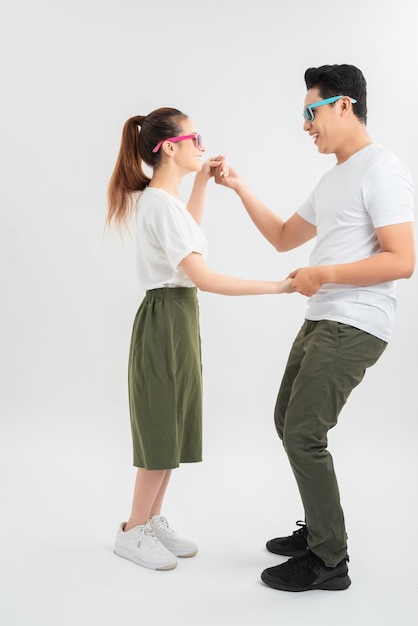 Casal sorridente dançando e segurando as mãos isoladas em branco