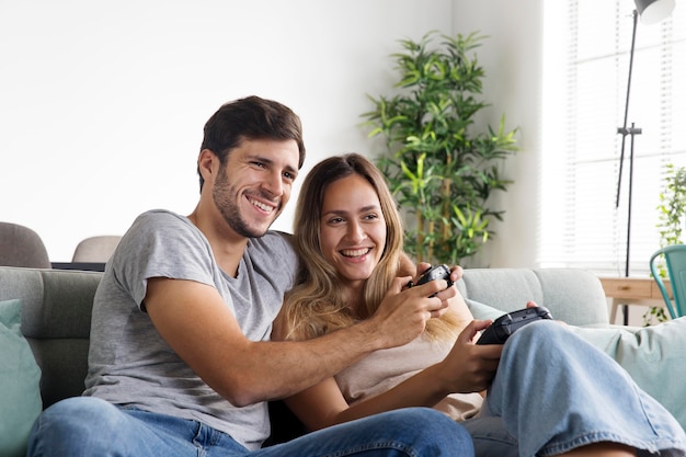 Foto casal sorridente de tiro médio jogando