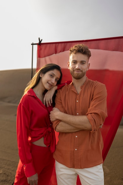 Casal sorridente de tiro médio posando no deserto