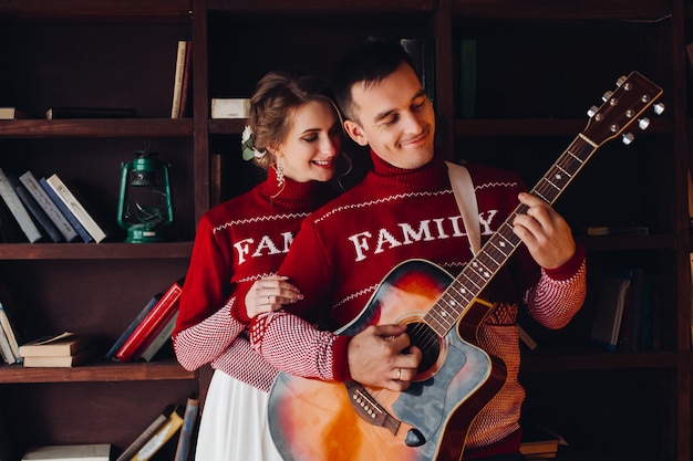 casal sorridente em blusas vermelhas, ouvir música