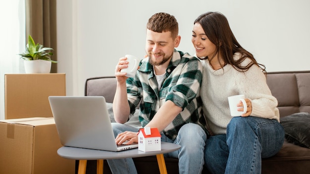 Casal sorridente em foto média dentro de casa