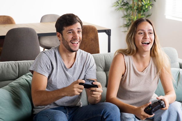 Foto casal sorridente jogando videogame médio